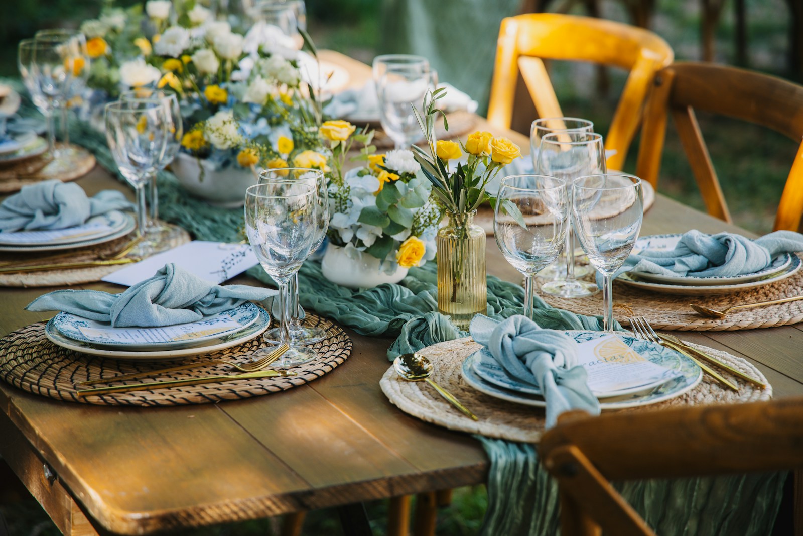 A beautifully set outdoor dining table with floral arrangements.